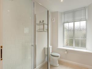 a bathroom with a toilet and a glass shower at Silverdale Apartment in Lindale +9 photos