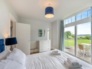 a bedroom with a white bed and a large window at Silverdale Apartment in Lindale