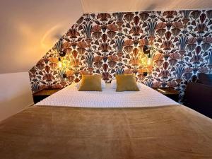 a bedroom with a bed with two yellow pillows at Logis Hôtel-restaurant Le Grand Cerf in Ernée