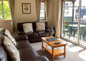 a living room with a couch and a table at Bure-Way And Rosemere in Wroxham