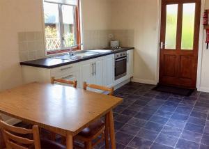 a kitchen with a wooden table and a table and a sink at Bure-Way And Rosemere in Wroxham