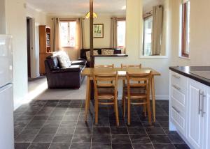 a kitchen with a table and chairs in a room at Bure-Way And Rosemere in Wroxham