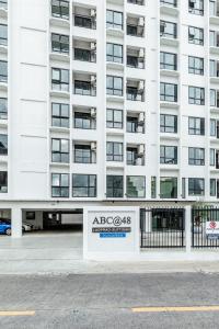 a large white building with a sign in front of it at ABC@48 Hotel & Service Apartment in Bangkok