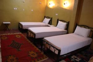 three beds in a room with white sheets at Kol izem in Ksar el Kbir +27 photos
