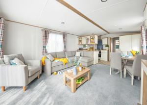 a living room with a couch and a table at Perran Heights Holiday Park in Perranzabuloe