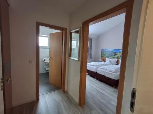 a room with a bedroom with a bed and a mirror at Linden's Pension-Restaurant in Ayl