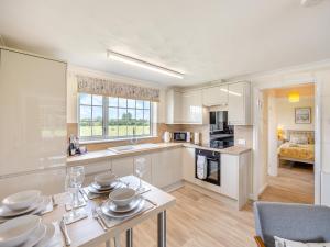 a kitchen and living room with a table and chairs at Oaks - Uk47372 in Burgh le Marsh