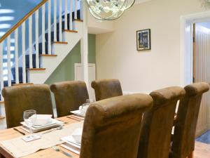 a dining room with a table with chairs and a staircase at Lowey's Harbour Cottage in Bridlington +25 photos