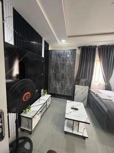 a living room with a television and a bed at Stylish Studio Near Jabi Mall in Gwarinpa