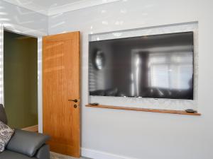 a flat screen tv hanging on a wall at Lowey's Harbour Cottage in Bridlington