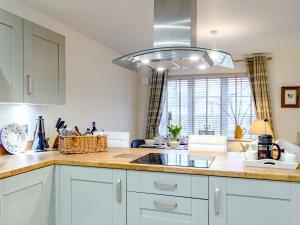 a kitchen with white cabinets and a light fixture at Popleys in Helmsley