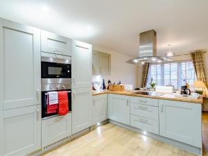 a kitchen with white cabinets and a stove top oven at Popleys in Helmsley +14 photos