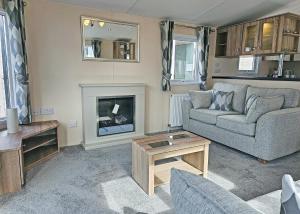 a living room with a couch and a fireplace at Aldbrough Leisure Park in Aldbrough