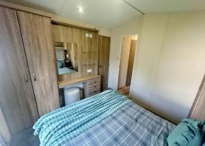 a small bedroom with a bed and a mirror at Aldbrough Leisure Park in Aldbrough