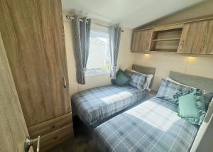 a small bedroom with two beds and a window at Aldbrough Leisure Park in Aldbrough +1 photo