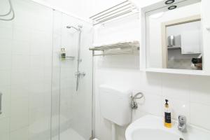a white bathroom with a shower and a sink at Dimora Saracena in Adrano +46 photos