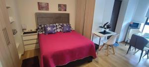a bedroom with a red bed with purple pillows at Edificio Paradisíaco,Cochabamba in Cochabamba