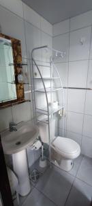 a white bathroom with a toilet and a sink at Edificio Paradisíaco,Cochabamba in Cochabamba