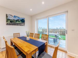 a dining room with a table and chairs and a large window at The Bunker - Uk47763 in Bamburgh