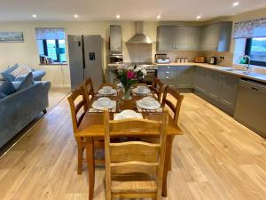 a kitchen and living room with a table and chairs at Moor Farm Lodge in Bawdeswell
