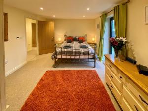 a bedroom with a bed with an orange rug at Moor Farm Lodge in Bawdeswell