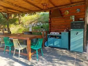 an outdoor kitchen with a wooden table and chairs at Habitat Eco Farm in Sorrento