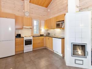 a kitchen with wooden cabinets and a white refrigerator at Kolin Lotus Superior-Amero Cottages in Kolinkylä +10 photos