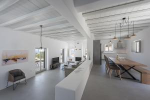 a white living room with a table and a dining room at Luxury Complex Ninemia Villas in Faros