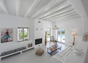 a white living room with a couch and a table at Luxury Complex Ninemia Villas in Faros