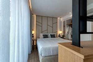 a bedroom with a white bed and a large window at Lemar Luxury Apartments in Hersonissos +90 photos
