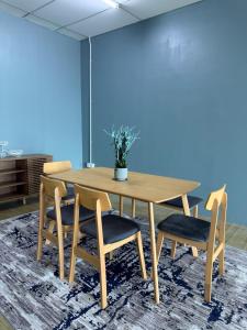 a wooden table and chairs with a potted plant on it at Tido Cottage in Macang +7 photos