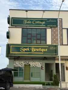 a building with a sign for a seek boutique at Tido Cottage in Macang