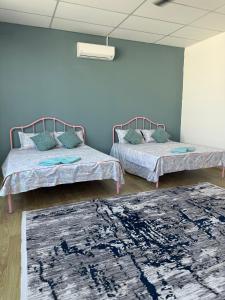 a room with two beds and a rug at Tido Cottage in Macang