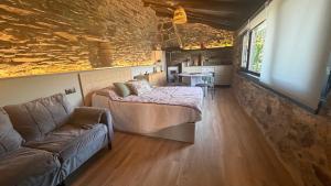 a room with a bed and a couch and a table at Mourulle in Insúa
