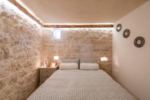 a bedroom with a bed and a stone wall at Casa20 in Cisternino