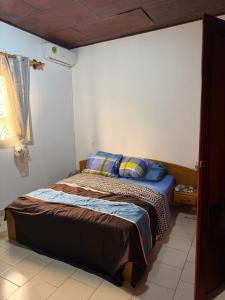 a small bedroom with a bed with blue pillows at Manoir des Princesses in Yaoundé