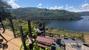 a wooden deck with a bench overlooking a lake at Mourulle in Insúa