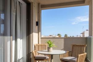 a balcony with a table and chairs and a window at Lemar Luxury Apartments in Hersonissos