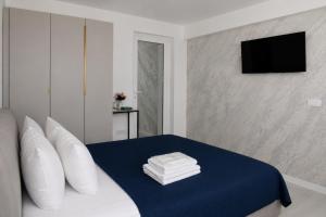 a bedroom with a bed with white pillows and a television at Casa Irina 2Mai in 2 Mai