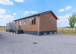 a small house in a gravel parking lot at Larkrise Farm Lodges in Babcary +12 photos