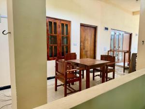 a dining room with a wooden table and chairs at Leaf Villa in Arugam Bay +50 photos