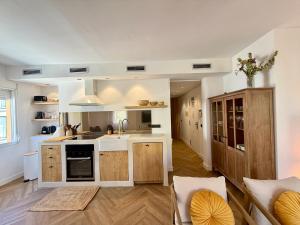 an open kitchen with white counters and wooden cabinets at Moraira Castle Boutique Apartment in Moraira +8 photos