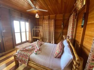 a bedroom with a bed in a wooden room at Monte Mar SãoTomé in M. Peixe