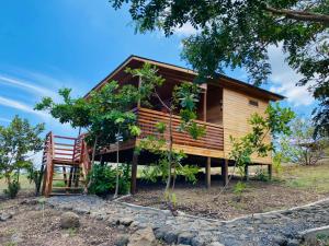 a log cabin with a bench and a tree at Monte Mar SãoTomé in M. Peixe