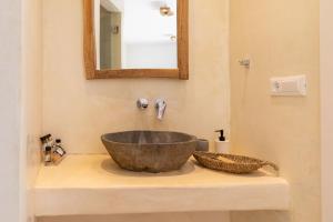 a bathroom with a bowl sink and a mirror at Casa Philippi Suites in Mikonos +26 photos