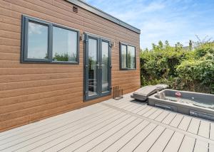 a house with a hot tub on a deck at Calvesland Hideaway in Manorbier +15 photos
