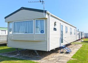 a white tiny house on display in a yard at The Chase Holiday Park in Addlethorpe