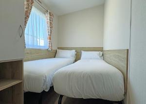 two beds sitting next to each other in a room at The Chase Holiday Park in Addlethorpe +31 photos