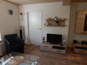 a living room with a flat screen tv on a dresser at Schlupfwinkel Mohnen Mit E-Ladestation in Clausthal-Zellerfeld