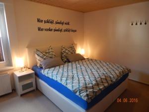a bedroom with a bed with a sign on the wall at Schlupfwinkel Mohnen Mit E-Ladestation in Clausthal-Zellerfeld
